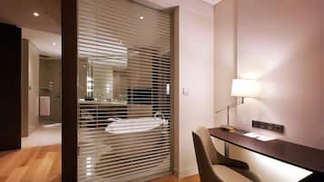 Un baño moderno con separador de vidrio, un lavamanos y un espejo.