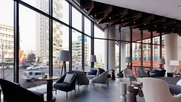 A modern interior with large windows, contemporary furniture, and a view of the cityscape.