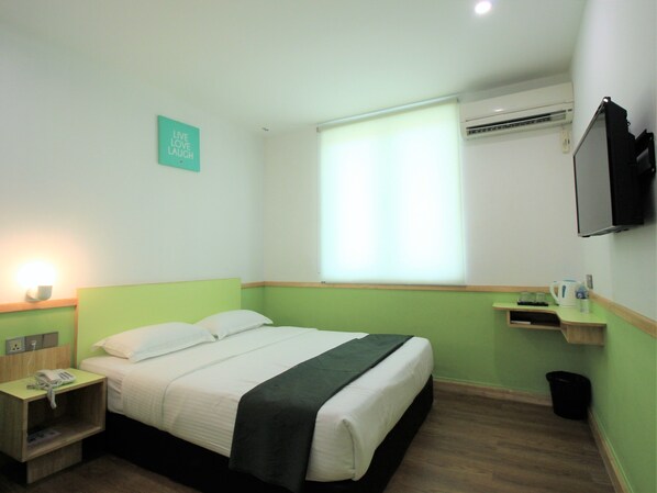 A hotel room with a bed, bedside table, lamp, air conditioning unit, and a television. - Jsia Hotel (Kota Kinabalu)