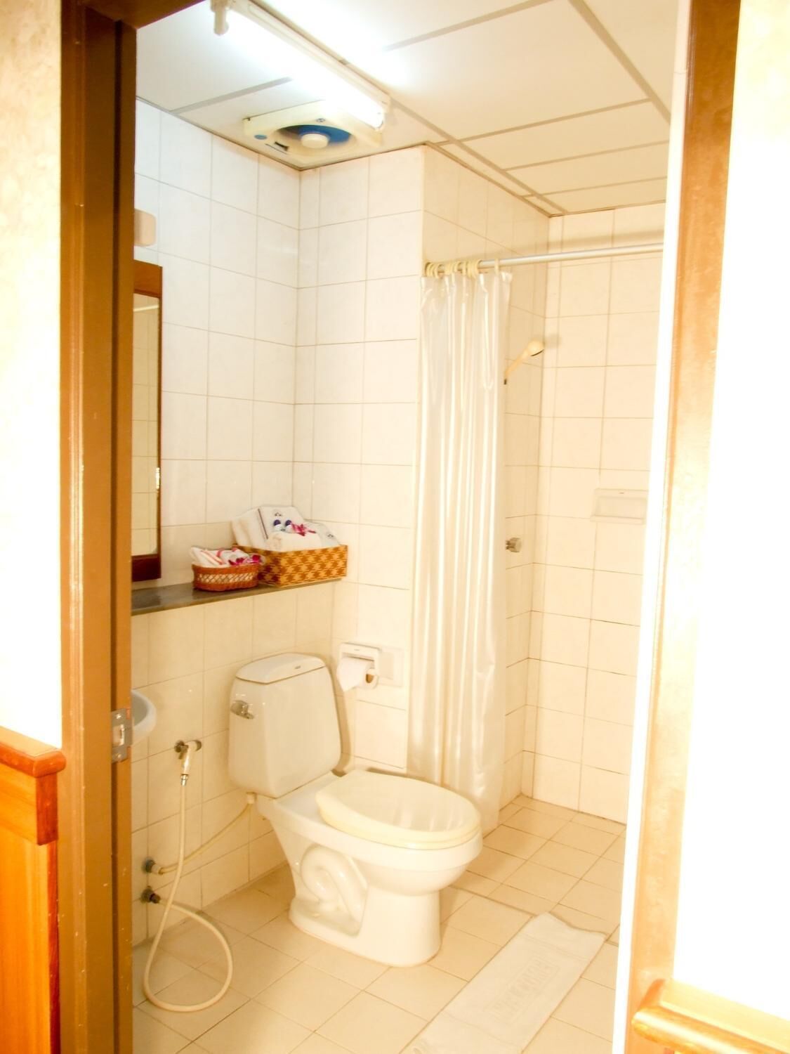 A small bathroom with a toilet, a shower, and a sink.