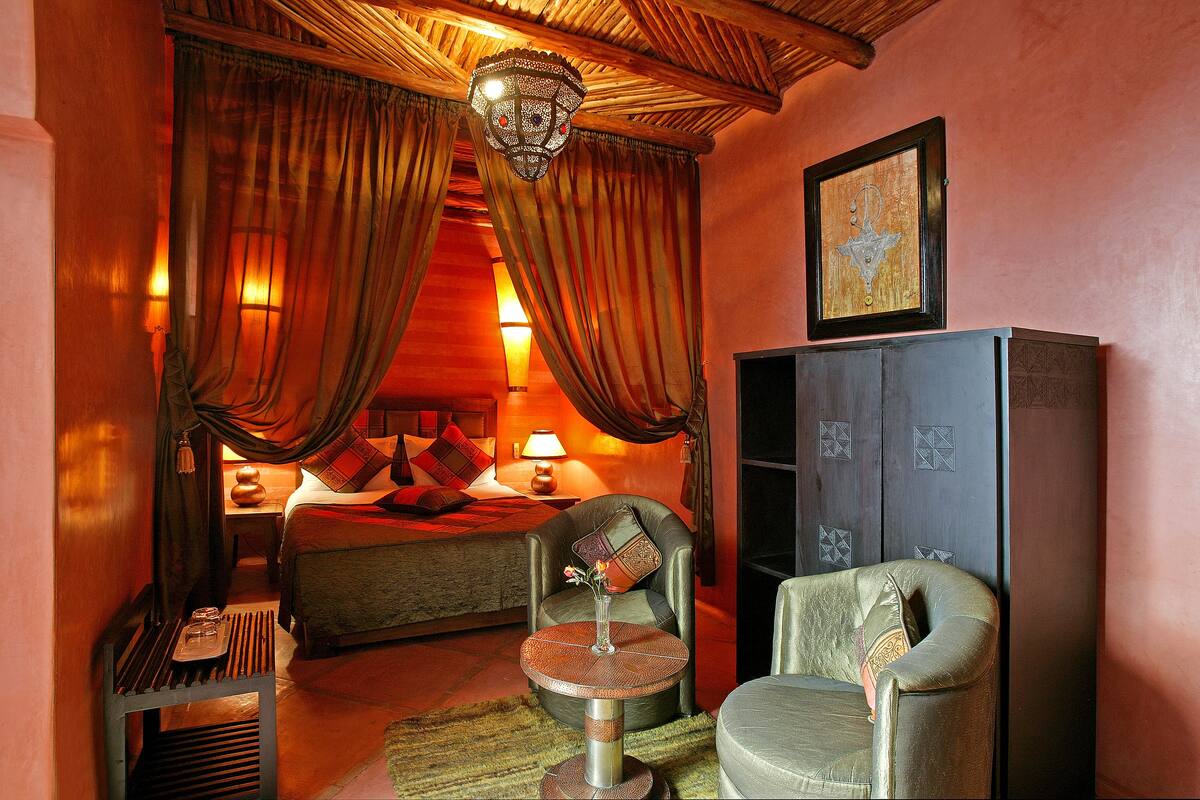 Une chambre d’hôtel avec un lit, une chaise, une table et une armoire.