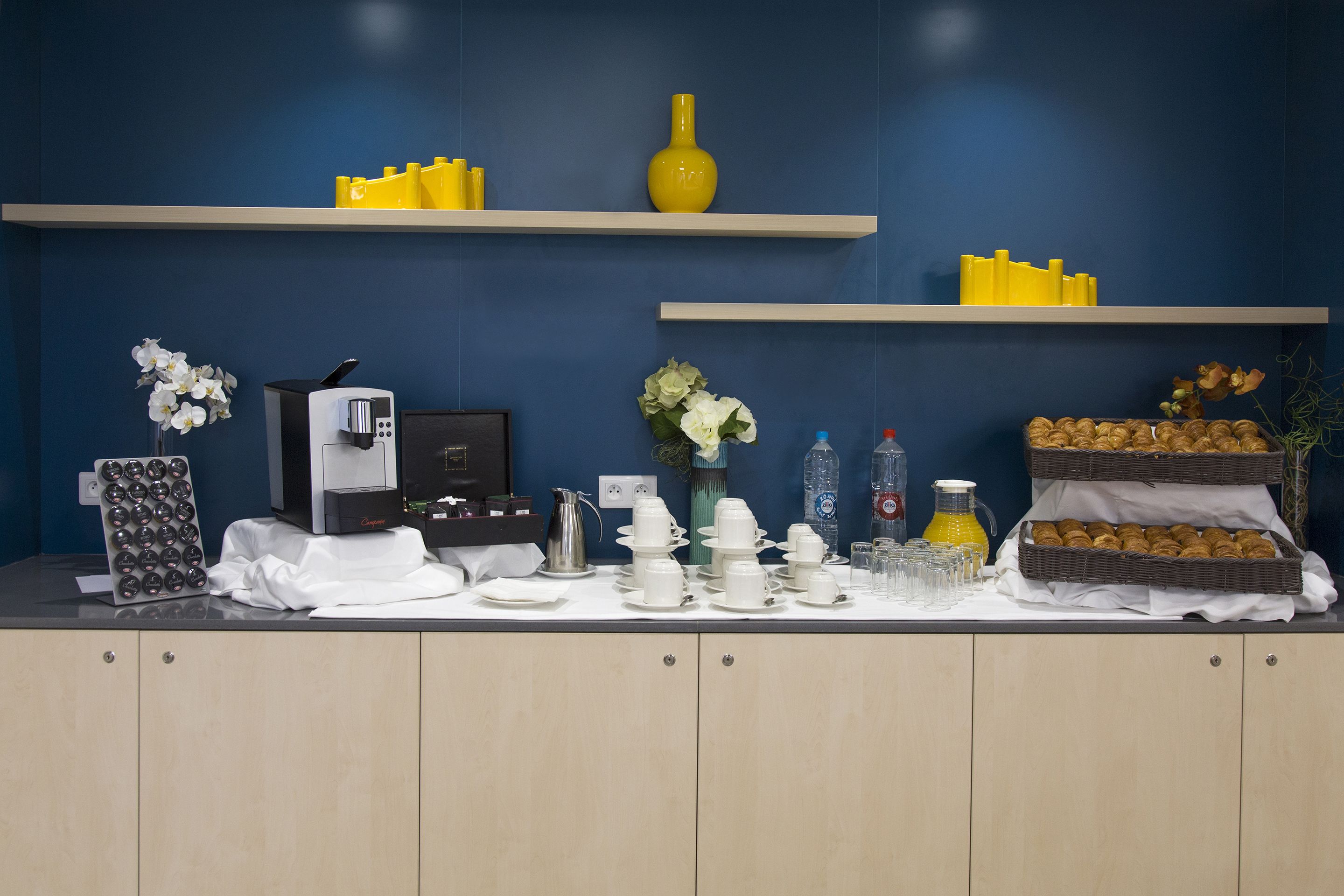 Buffet de l'esmorzar preparat amb màquines de cafè, assortiment de tes i varietat de pastissos.
