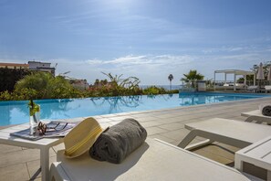 A poolside area with lounge chairs, a sun umbrella, and a pool. - Résidence de Tourisme Ajaccio Amirauté (Ajaccio)