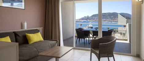A balcony with a view of the sea and a cityscape.