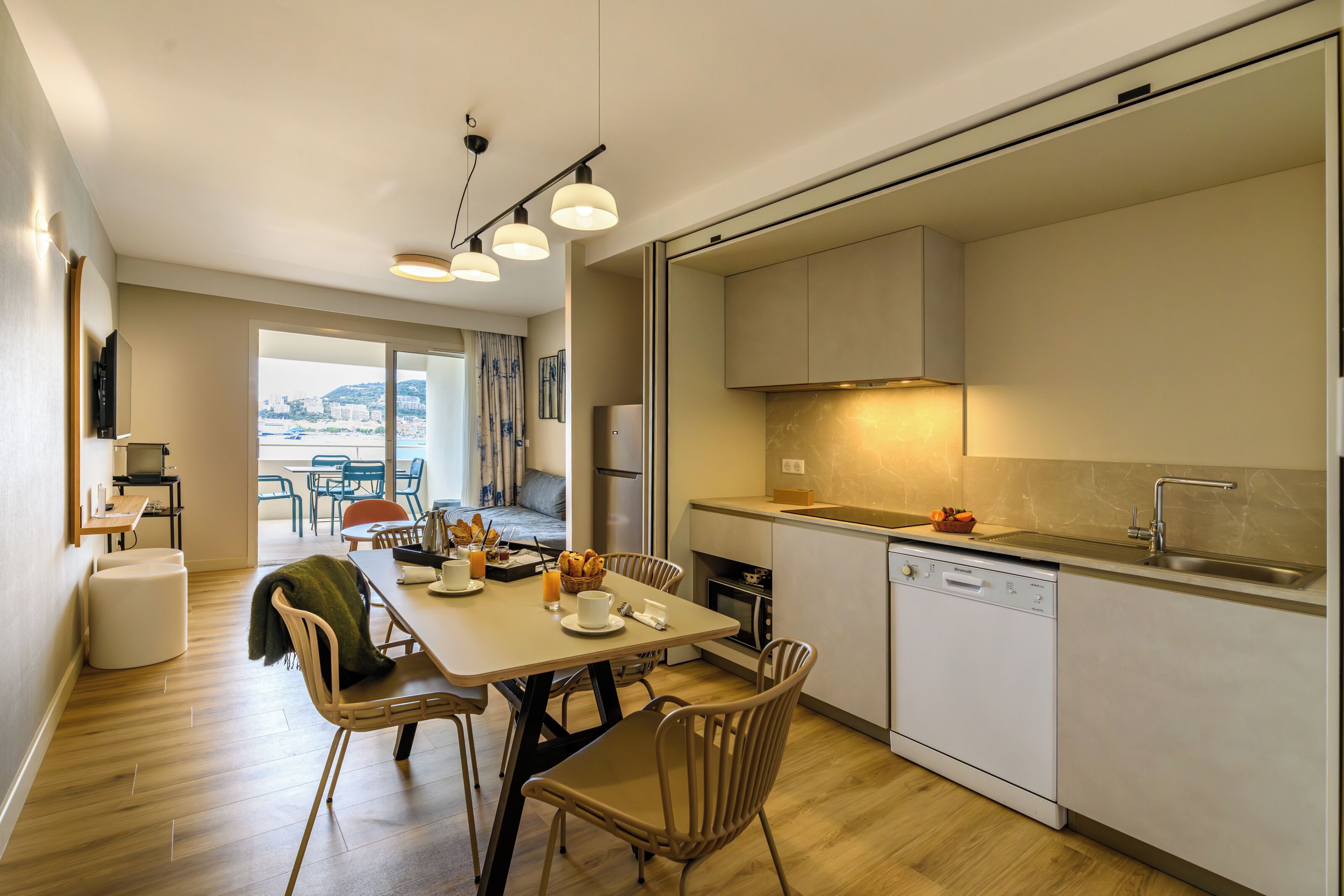 Une cuisine moderne avec un coin repas, un lave-vaisselle et une vue sur la ville.