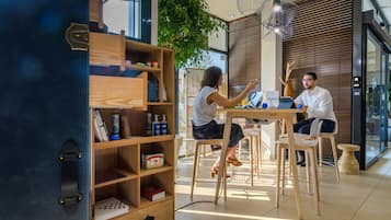 A modern interior with a wooden desk, chairs, and a bookshelf.