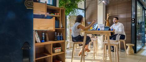 A modern interior with a wooden desk, chairs, and a bookshelf.