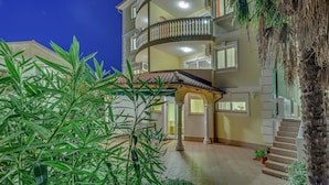 A multi-story building with balconies, a covered entrance, and a staircase leading to the upper floors. - Charming Countryside Escape (Crikvenica)