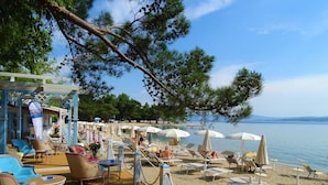 A beachside area with lounge chairs, umbrellas, and a poolside seating area. - Charming Countryside Escape (Crikvenica)