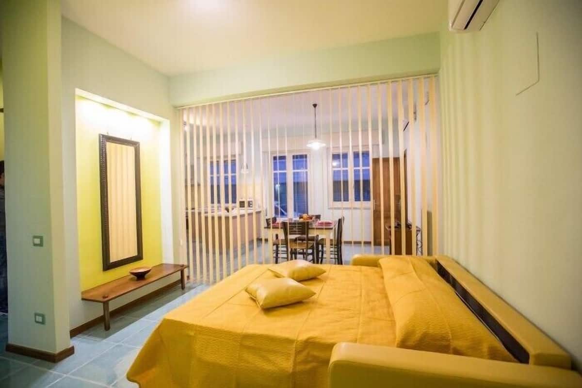 Una habitación con una cama, un banco, una mesa y una silla.