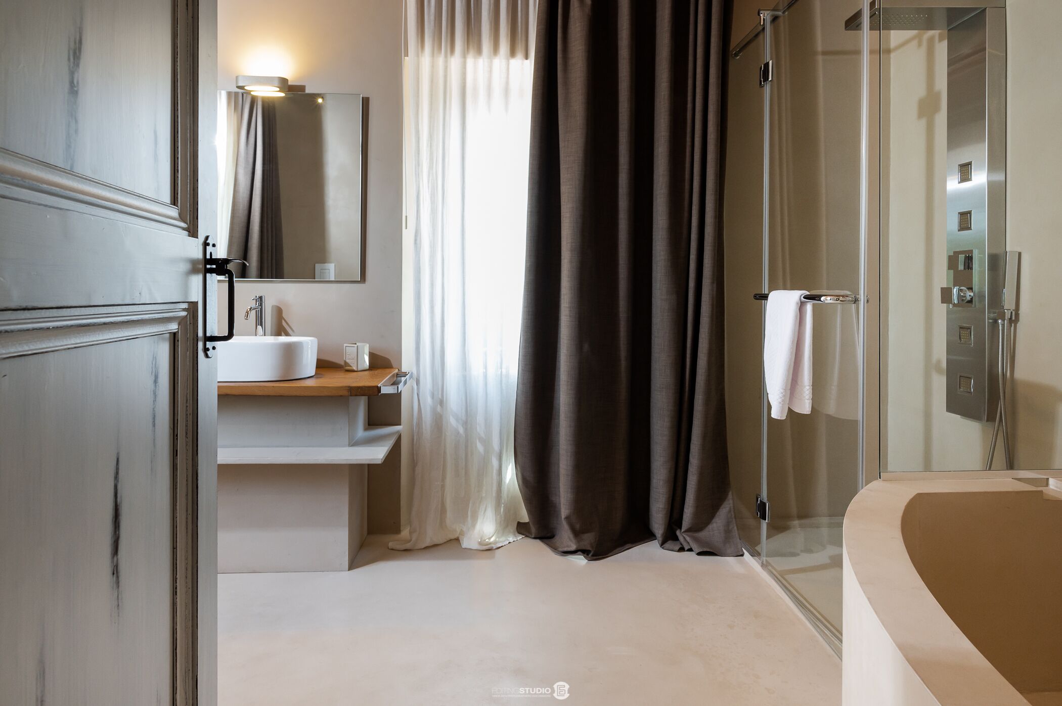 A modern bathroom with a large bathtub, a glass shower enclosure, and a vanity with a mirror and sink.