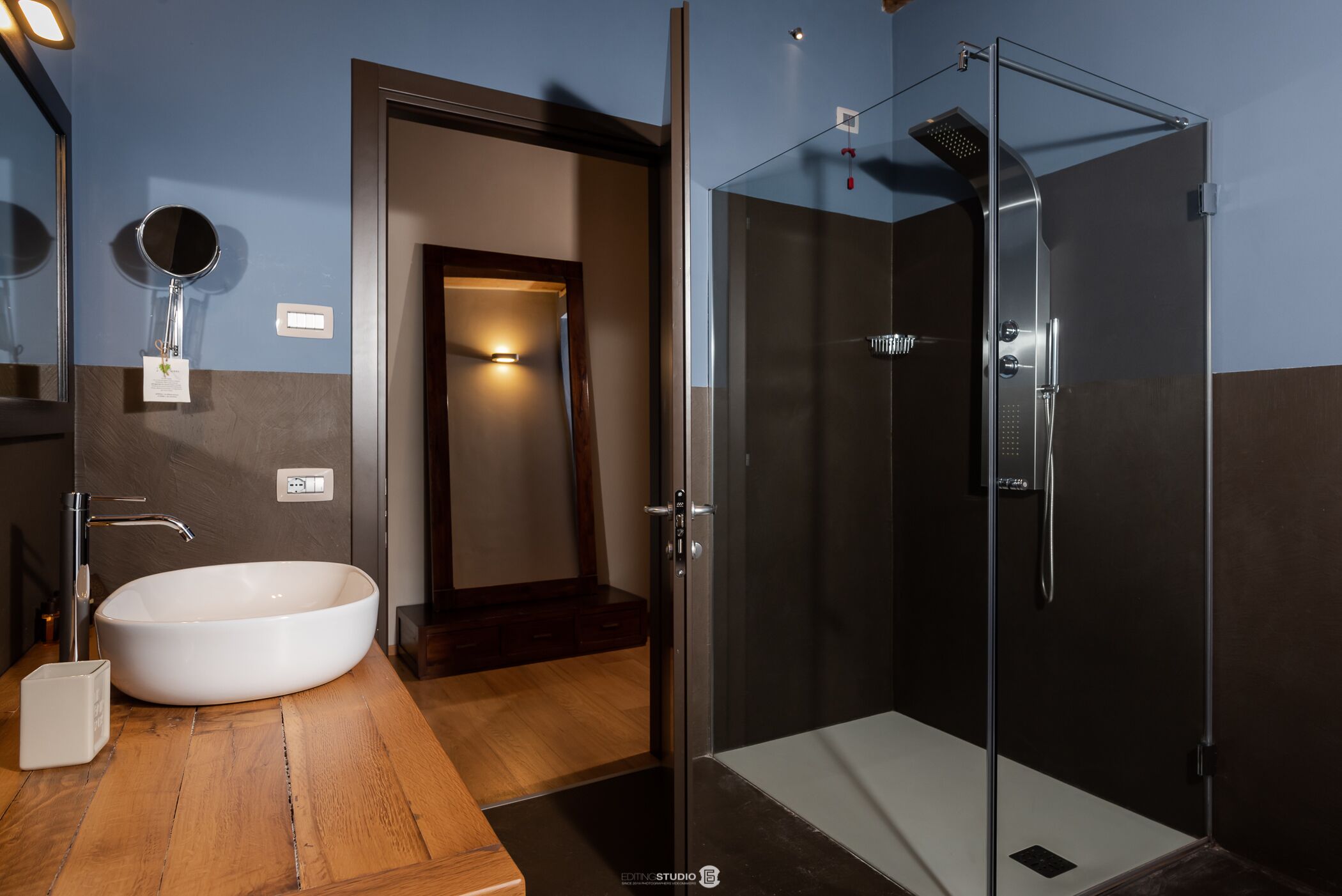A modern bathroom with a freestanding bathtub, a glass-enclosed shower, and a wooden vanity.