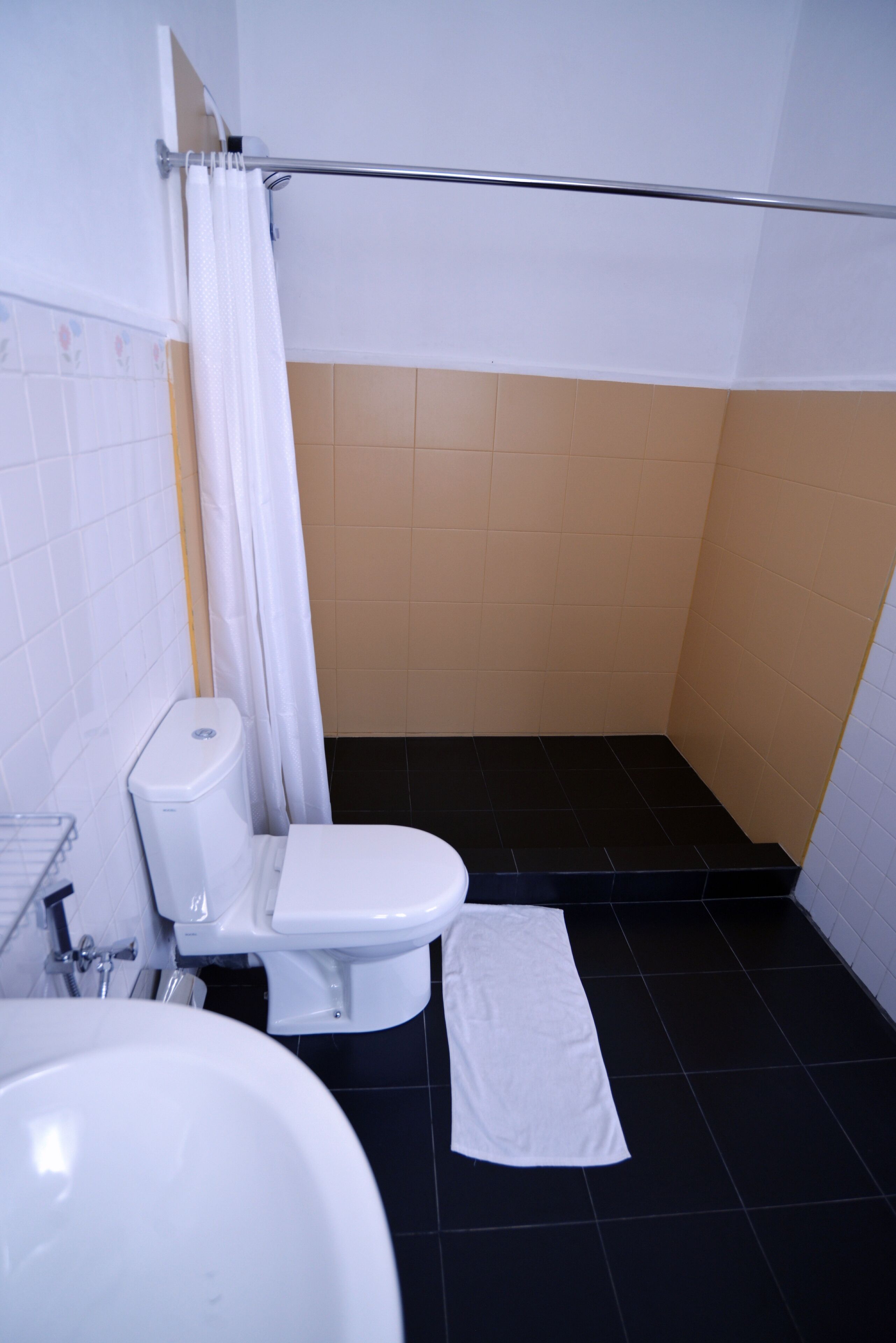 Une salle de bain comprenant des toilettes, un lavabo et un espace douche.