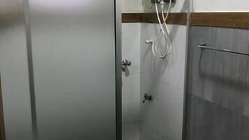Un baño moderno con ducha envuelta en cristal, un inodoro y un lavamanos.