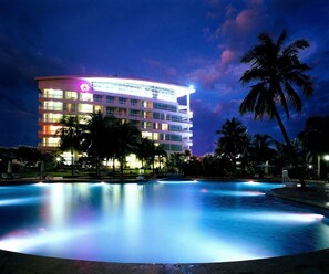 A multi-story hotel with a pool area at night. - Sunshine Resort Intime Sanya (Sanya)