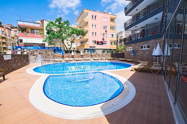 Piscine extérieure, parasols de plage, chaises longues