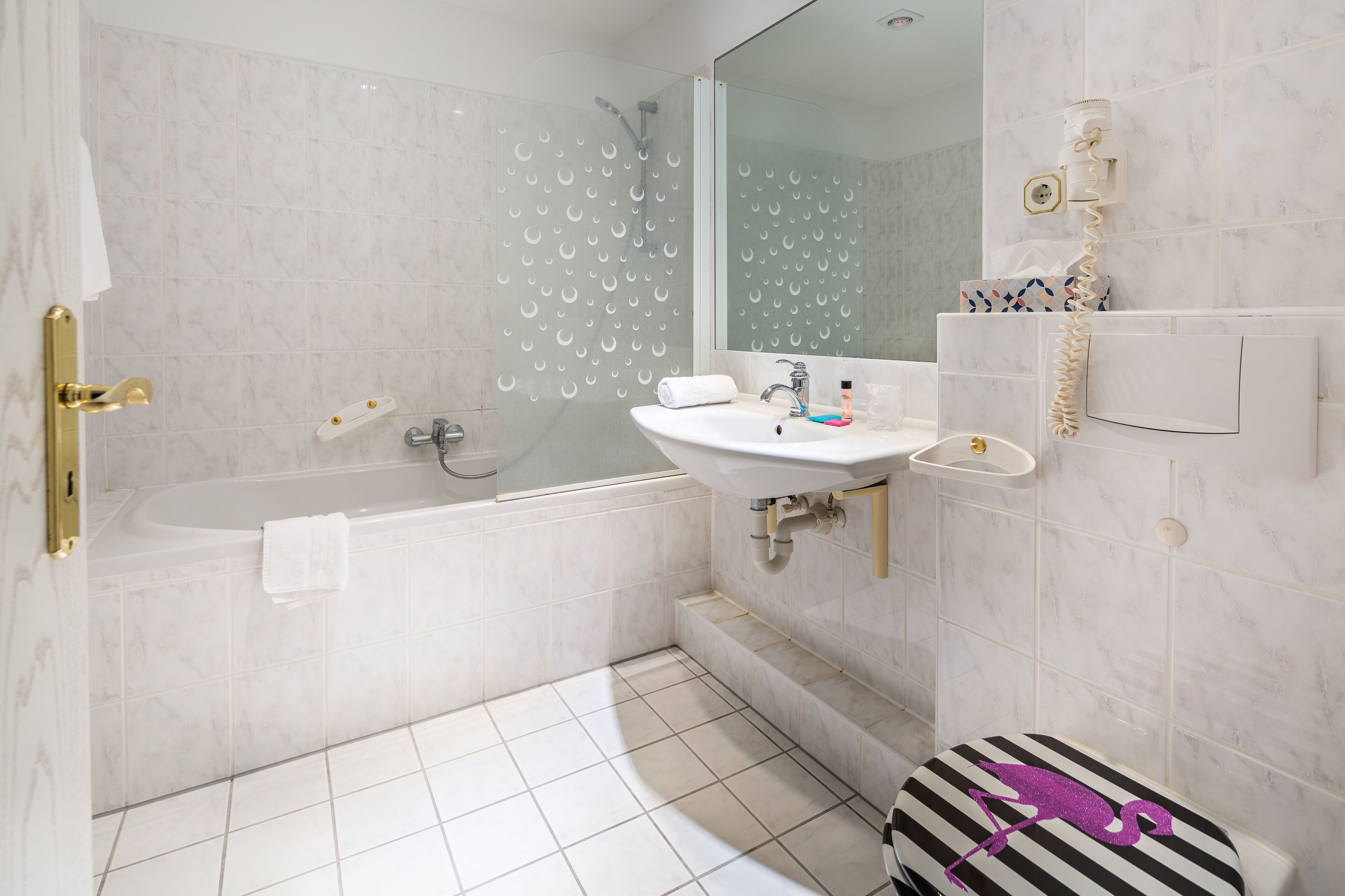 A modern bathroom with a bathtub, sink, and toilet.
