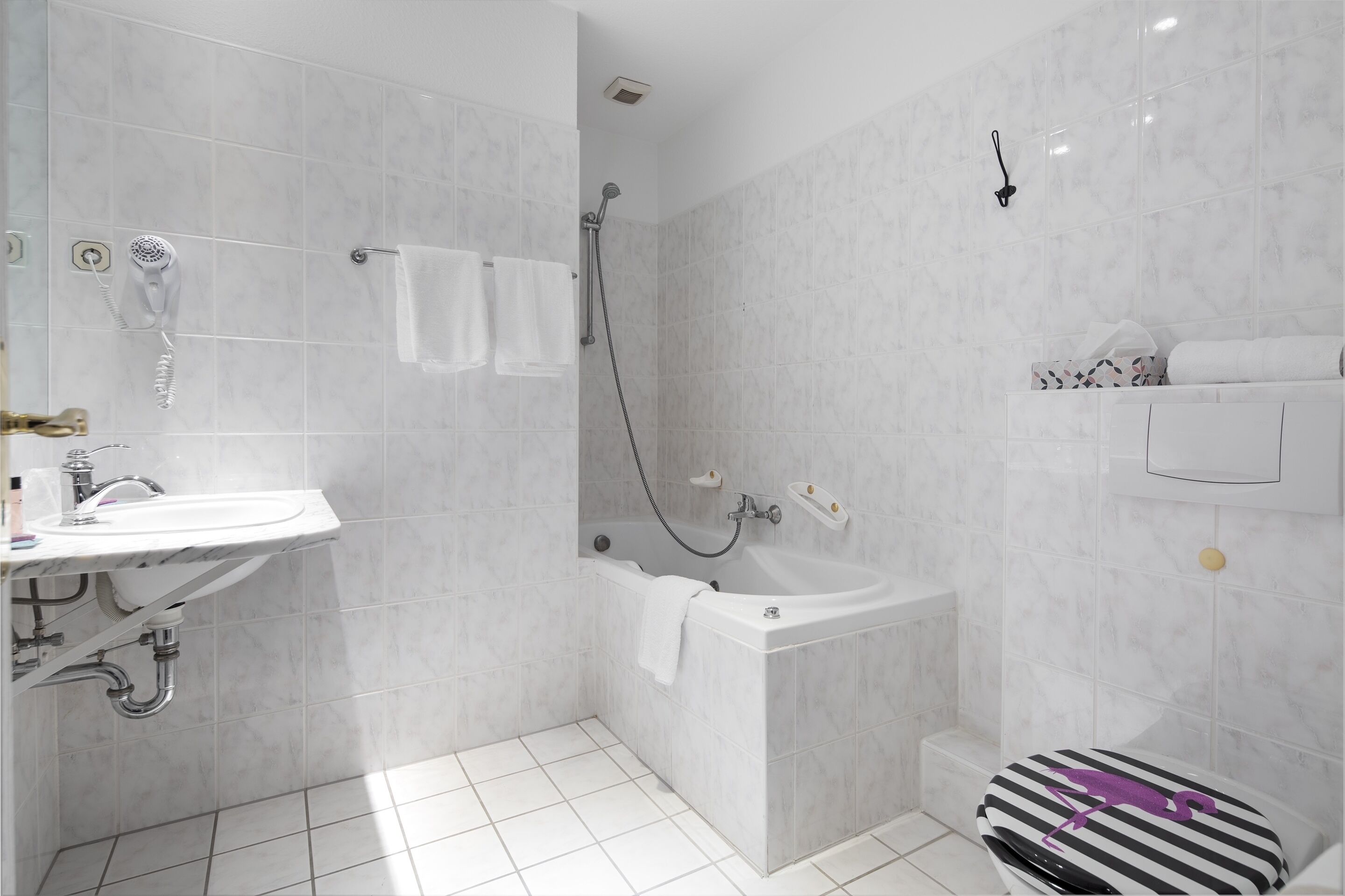 A modern bathroom with a bathtub, a shower, and a toilet.