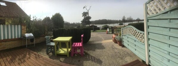 A patio with a grill, a table, and a chair.