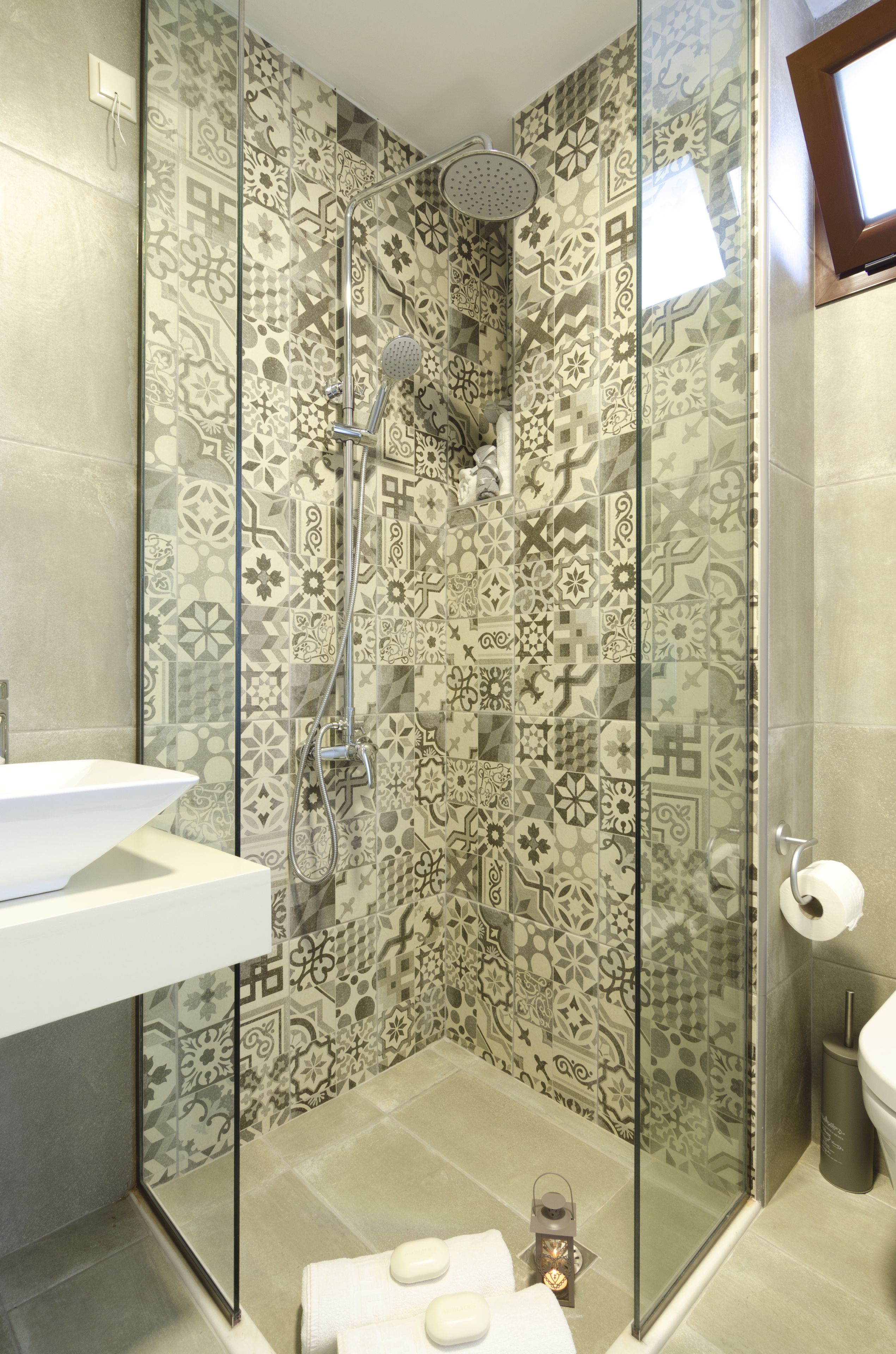 A shower with a glass door, a sink, and a toilet.