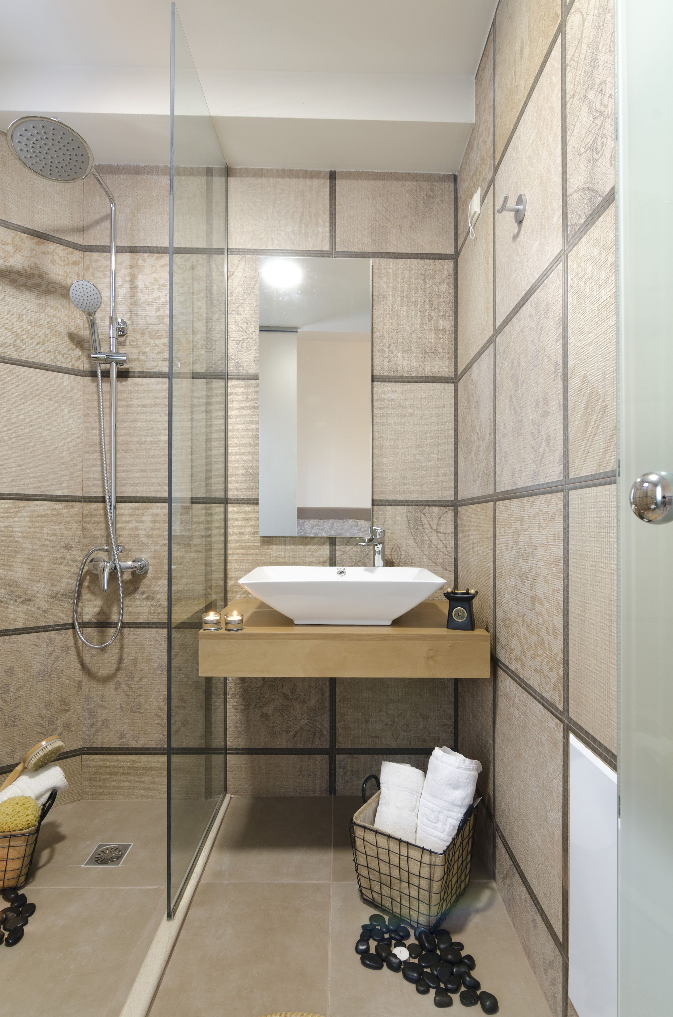 Une salle de bain moderne avec une douche à parois de verre, un meuble-lavabo en bois et un porte-serviettes.