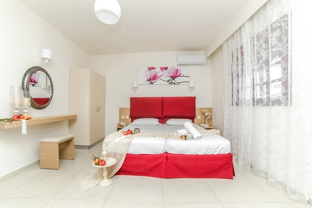 Een moderne slaapkamer met een groot bed, een nachtkastje, een spiegel en een wandairconditioner.