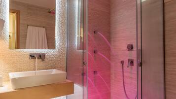 A modern bathroom with a glass-enclosed shower, a sink, and a mirror.
