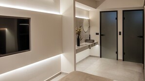 Un baño moderno con un espejo grande, un lavamanos integrado y un inodoro.