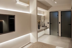 Un baño moderno con un espejo grande, un lavamanos integrado y un inodoro.