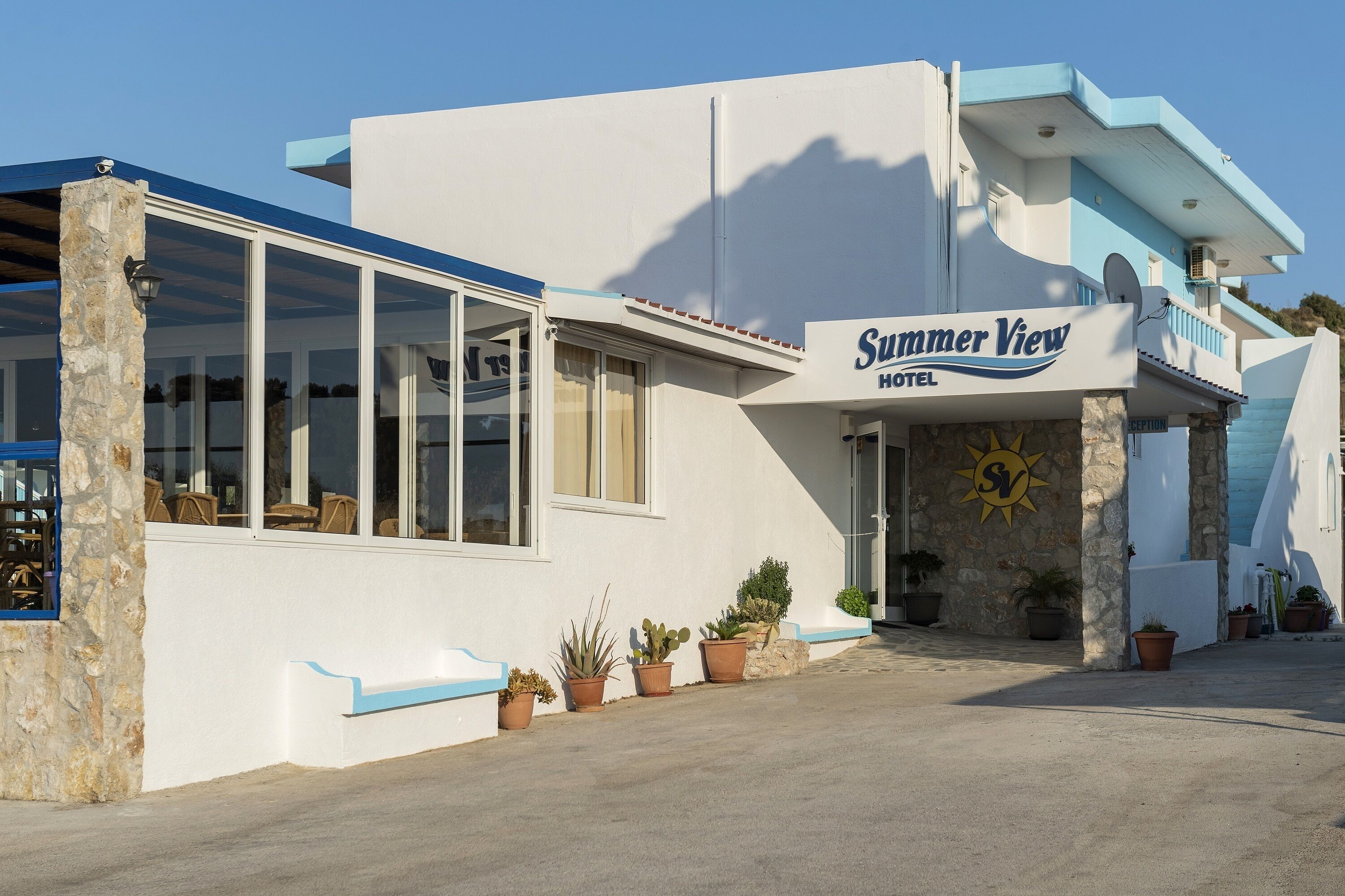 A hotel named Summer View with a modern design, large windows, and potted plants.