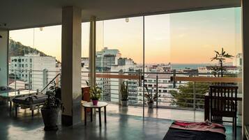 Relax and work in style with a spacious living area featuring a balcony overlooking the city and sea.