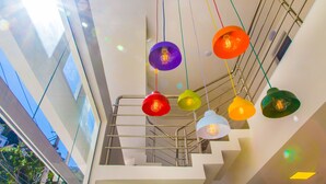 Un intérieur moderne agrémenté d’un escalier et de luminaires suspendus aux couleurs vives.