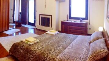 A bedroom with a large bed, a dresser, a mirror, and a television.