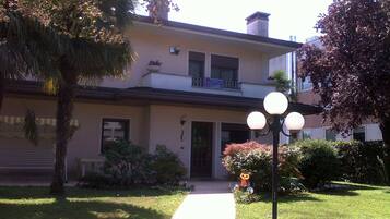 A two-story building with a front entrance, a small porch, and a well-maintained lawn.