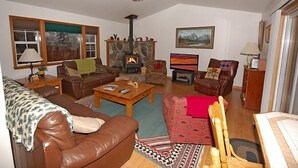A cozy living room with a fireplace, leather sofas, a coffee table, and a television. - 1209 Golden Bear 3 Bedroom Home by RedAwning (South Lake Tahoe)