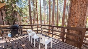 A wooden deck with white plastic chairs and a grill. - 1360 Knoll Lane 3 Bedroom Home by RedAwning (South Lake Tahoe)