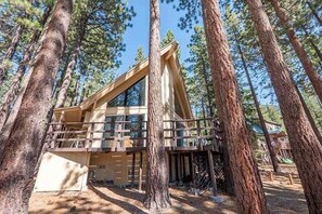 A cabin with a balcony, surrounded by tall pine trees. - 1360 Knoll Lane 3 Bedroom Home by RedAwning (South Lake Tahoe)