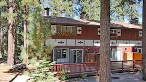 A two-story building with a red exterior, large windows, and a deck with a red railing. - 1510 Wildwood, 6 2 Bedroom Condo by RedAwning (South Lake Tahoe)