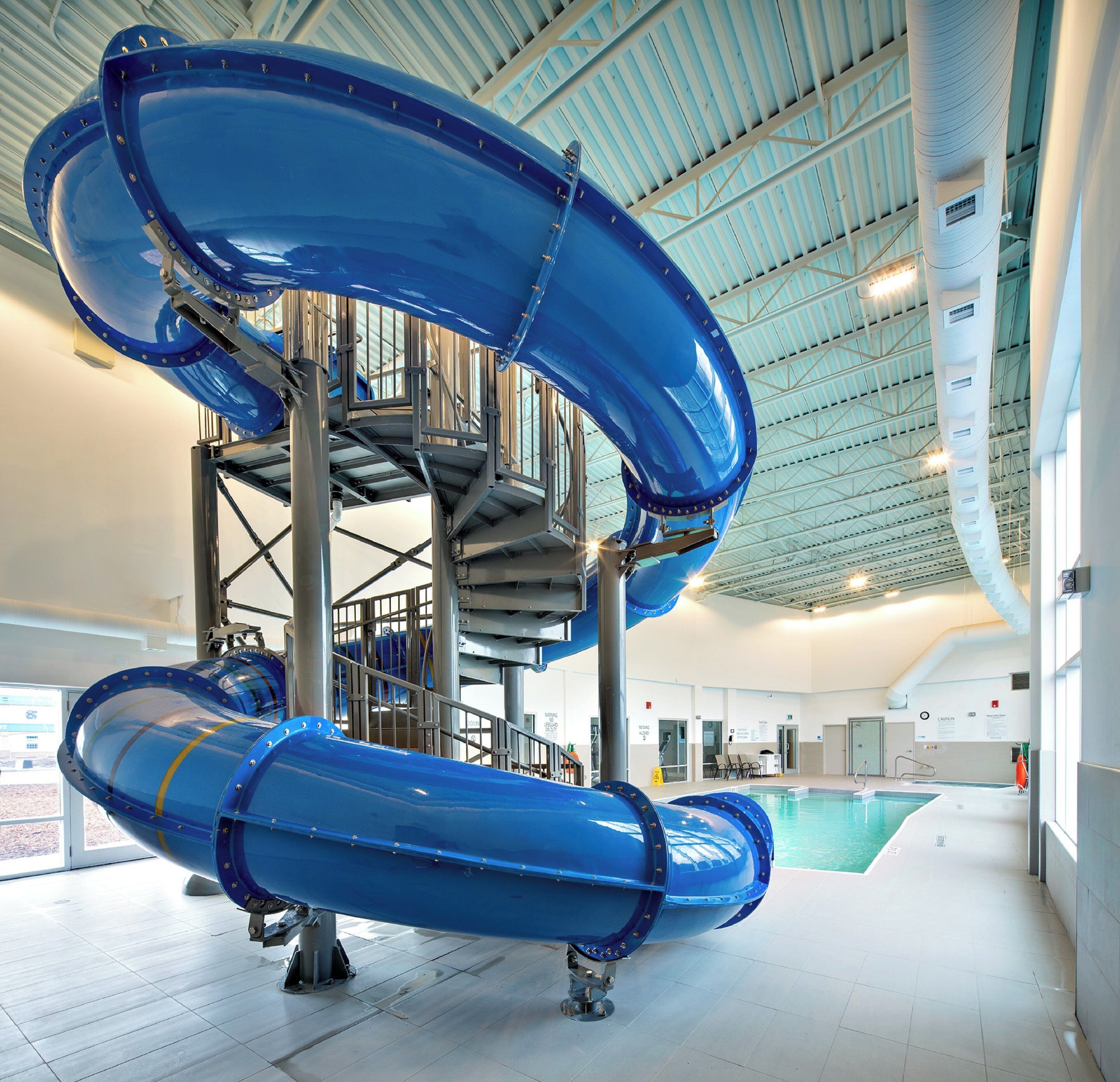 Un grand toboggan aquatique intérieur doté de plusieurs pistes et d’un escalier central.