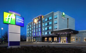 Un hotel Holiday Inn Express amb disseny modern, amb un senyalitzador ben visible i una entrada ben il·luminada.