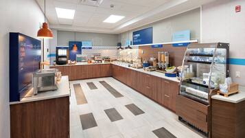 Un espace moderne dédié au petit-déjeuner, avec un buffet où l’on se sert soi-même, un bar à jus et un coin boulangerie.