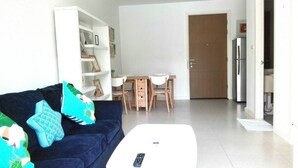 A living room with a sofa, a coffee table, and a dining area with a table and chairs. - The Seacraze Hua Hin by Montri (Hua Hin)