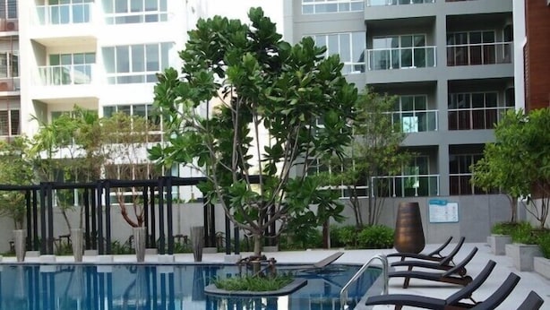 A swimming pool with lounge chairs and a tree in the center. - The Seacraze Hua Hin by Montri (Hua Hin)