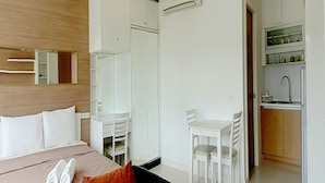 A hotel room with a bed, a desk, a chair, a kitchenette, and a bathroom. - The Seacraze Hua Hin by Montri (Hua Hin)