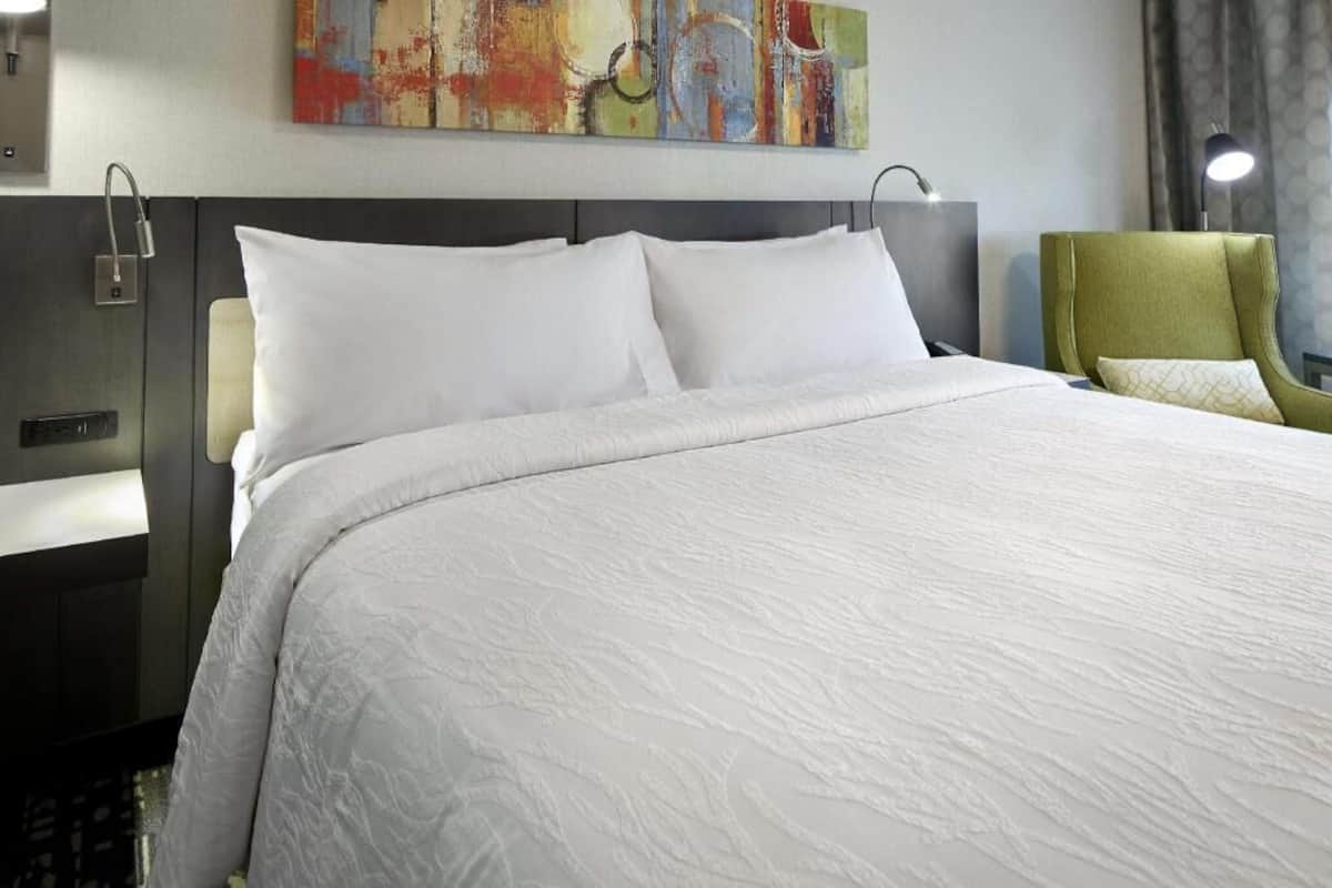 Ropa de cama hipoalergénica y caja de seguridad en la habitación