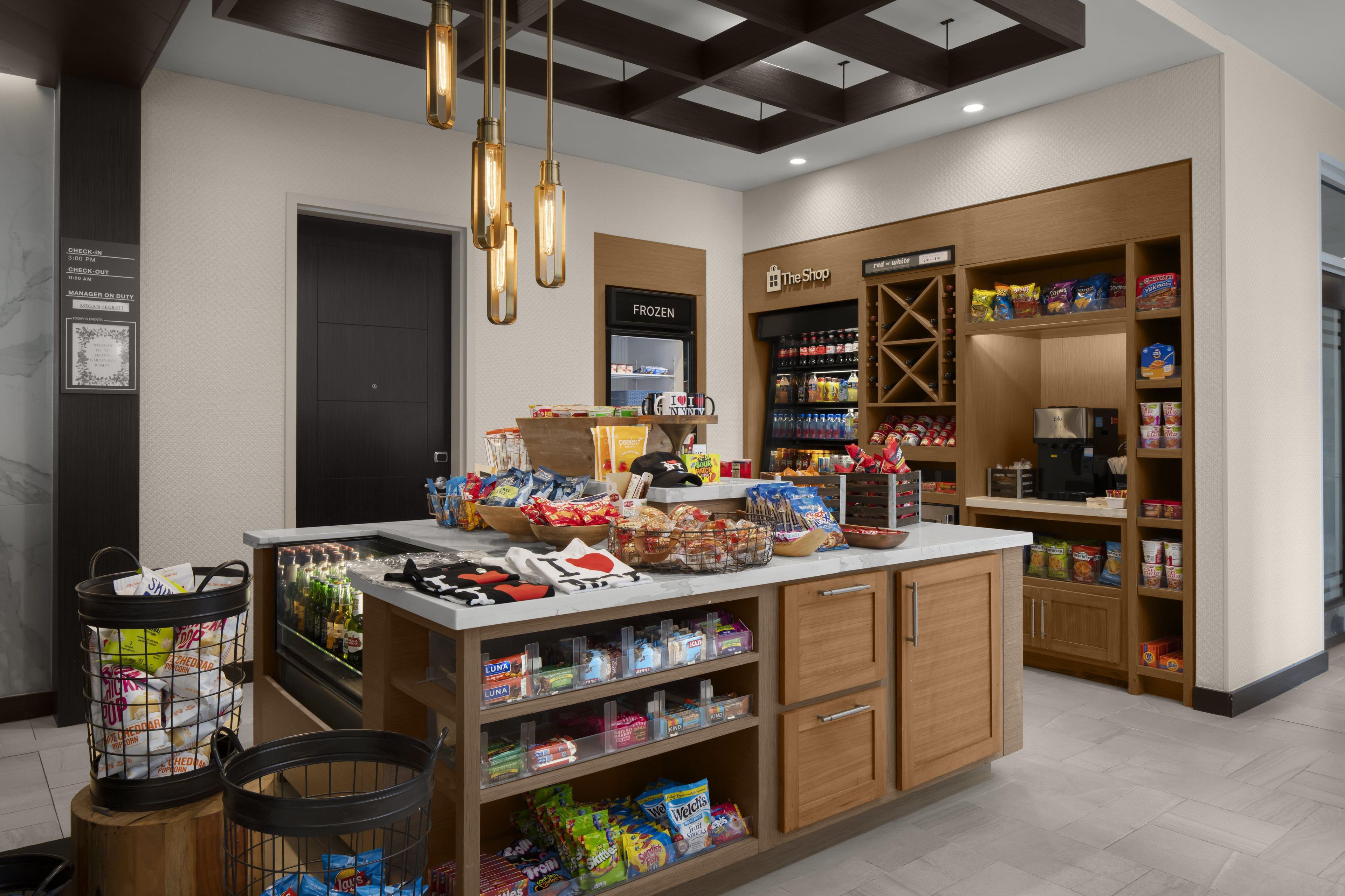 A well-organized snack bar with a variety of food items and beverages, a freezer section, and a coffee machine.