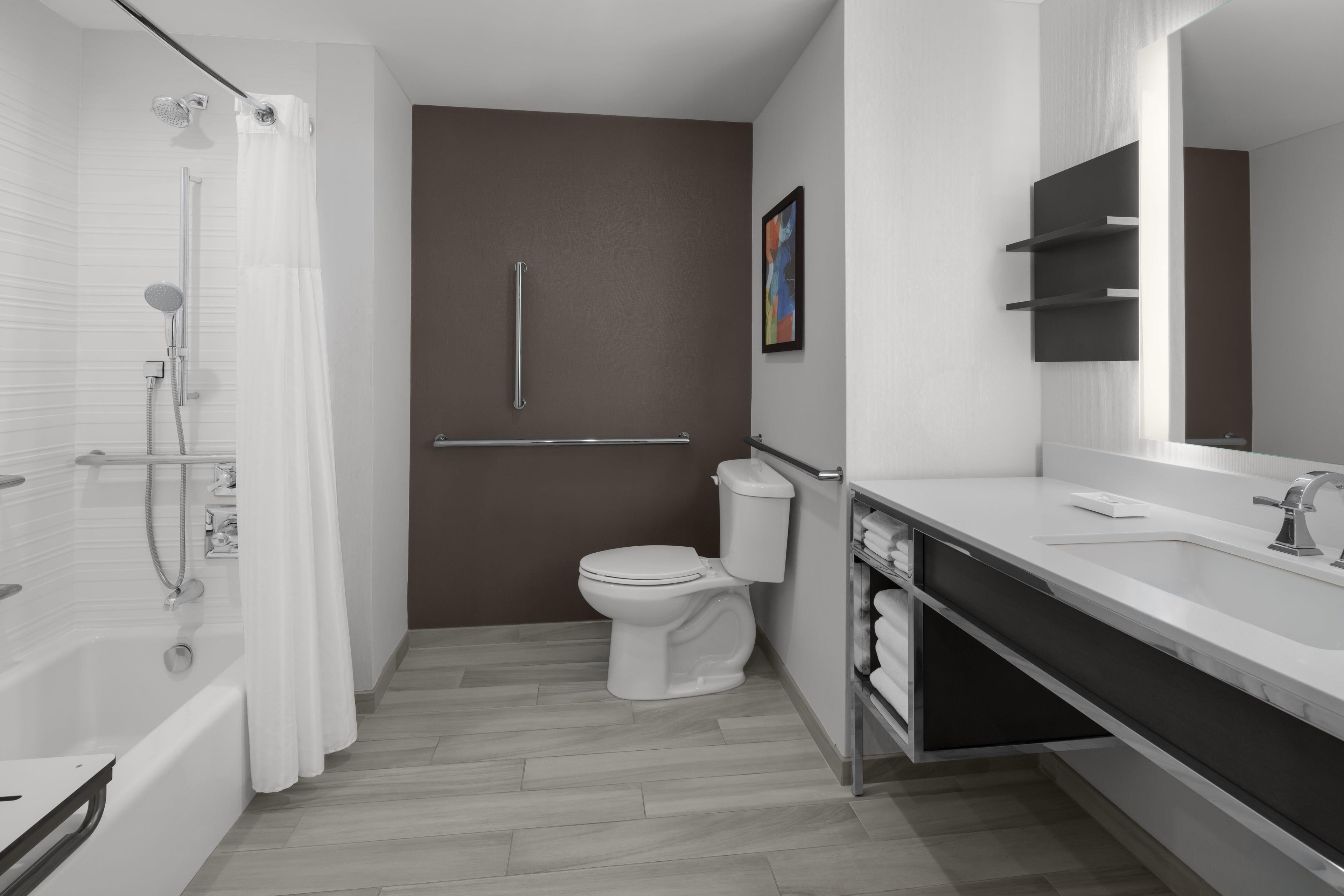 A modern bathroom with a shower, toilet, and sink.