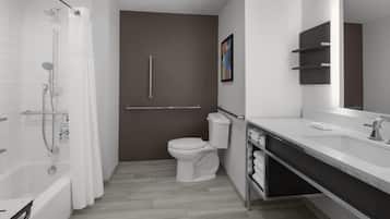 A modern bathroom with a shower, toilet, and sink.