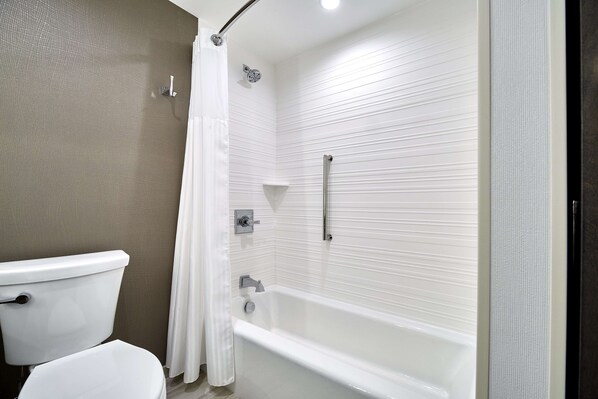 A bathroom with a toilet, a bathtub, and a shower.