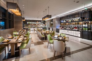 A modern restaurant with multiple dining areas, a bar, and a buffet.